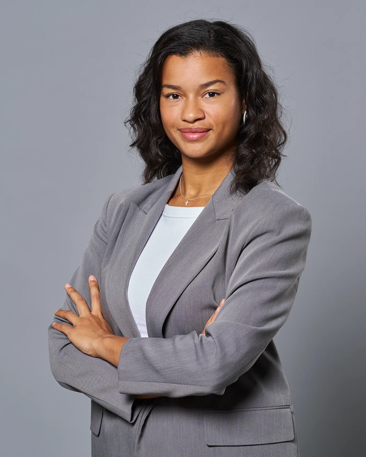 Business Portrait Frau im grauen Blazer vor grauem Hintergrund — FAYCE Bern